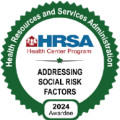 A circular green badge with the text Health Resources and Services Administration around the edge. Center text reads HRSA Health Center Program, Addressing Social Risk Factors, 2024 Awardee—recognizing Montrose Health Care’s commitment to quality healthcare.