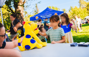 Children meeting Manny Molar, a dental education puppet, at Rocky Mountain PBS KIDS Fest